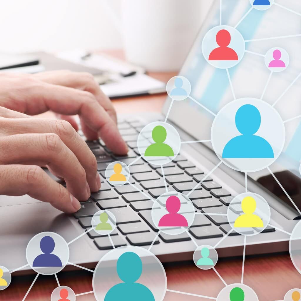 Users-Group A web of colorful people icons on top of a background of a person typing on a laptop
